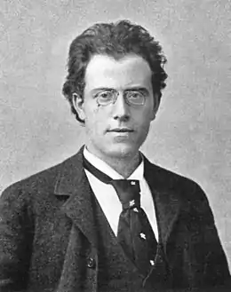 Black and white photograph of a man with glasses wearing a suit and tie