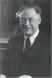 Head and a torso of a smiling bolding man in his fifties, dressed in a dinner suit