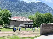 Kids playing soccer on Higher Scondary School 33 Note playing field.