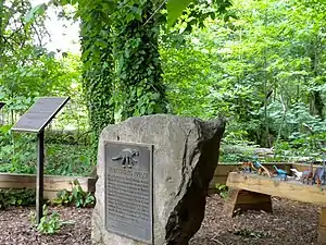 Plaques at the site showing National Historic Landmark status (left) and a plaque from Philadelphia's Academy of Natural Sciences. A deep pit or ravine is straight ahead about 10 yards.