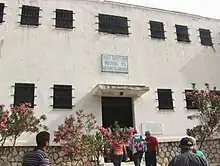 Photograph of a white two-storey building at he Haidari concentration camp