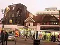 Middle section of Station Road, showing shops and the Time Building and apartments on Lyon Road behind it