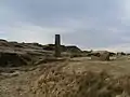 A view of the chimney, ruined buildings and spoil heaps of Musbury heights.