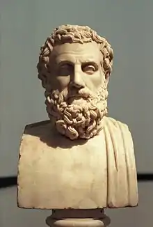 Stone bust of a male torso with curly hair and beard