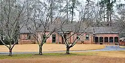 A brick home with brown trim and a large lawn in front.