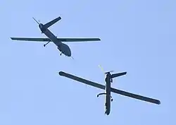 Two drones viewed from below in a blue sky