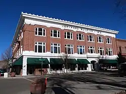 Photograph of a three-story building on a city street corner