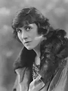 Black and white portrait of a white woman wearing a fur-trimmed coat.