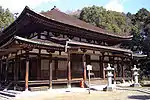 Wooden building with slightly raised floor, an open veranda and a pyramid shaped roof.