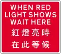 Used with temporary traffic signals. Vehicles must not proceed beyond the sign when red light shows.