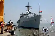 Large, grey ship at dockside