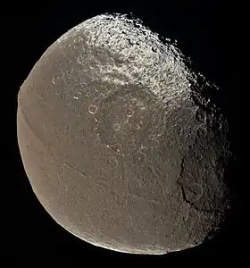 A global view of Iapetus  obtained by the Cassini spacecraft on Dec. 31, 2004 - the first-ever clear image of the ridge - at a distance of about 172,900 kilometers (107,435 miles). The massive structure clearly distorts the shape of the moon at the equator.