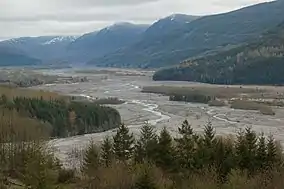 River flowing through valley surrounded by forested mountains