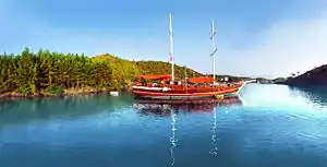 Traditional two-masted gulet schooner visiting a cove in Gökova as part of the Blue Cruise