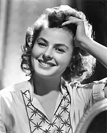 Promotional photograph of Ingrid Bergman for Gaslight. She is looking front, smiling and touching her hair.