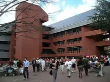 The intercultural center looms behind Red Square. Dozens of students are pictured in the plaza, many passing through, others sitting at tables demonstrating