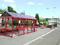 This was once a fairly grand station with two platforms, substantial buildings and a goods yard. It is now reduced to one platform with bus shelter. Dunrod Hill is visible in the distance, beyond the trees.