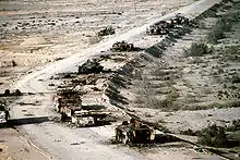 Iraqi armored personnel carriers, tanks and trucks destroyed in a Coalition attack along a road in the Euphrates River Valley during Operation Desert Storm, in 1991.