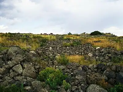 Thick piles of stones where fortifications had once been at the top of the hill.