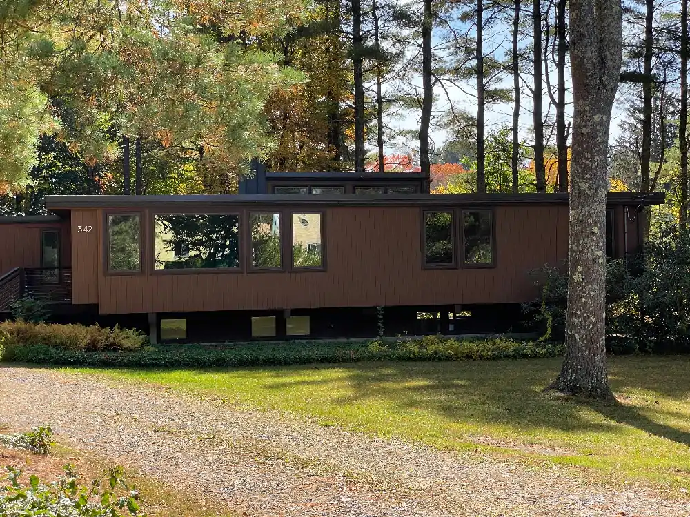 Isham Railey McConnell house in Sudbury MA. Note the flat roof with central ring of vertical skylights, the large picture windows, and the ground floor cantilevered over the foundations surrounding the basement.