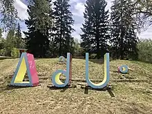 Large, brightly coloured sculptures of the Cree syllabics ᐃᐢᑯᑌᐤ (the word for "fire")