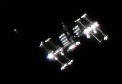 The International Space Station photographed by Vandebergh: "The image shows not only the ISS with very special lighting angle but also it shows activity around the ISS which is often the case. You see the Japanese Cargo Ship HTV-1 in its demonstration flight shortly before docking and just a few hundred meters below the ISS."