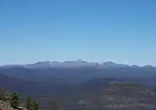 A large gently-sloped mountain rising above the surrounding area on a clear day