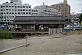 A more distant view of the station forecourt showing the parking lots and bike shed.