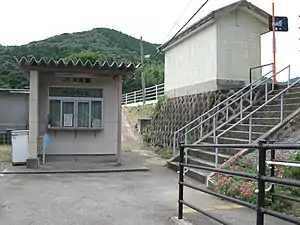 The disused ticket window shelter at the base of the embankment. In the foreground can be seen the ramp leading to the platform.