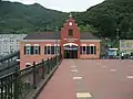 A distant view of the station, approaching it by way of the bridge from the theme park.