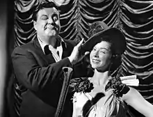 Jackie Gleason straightening a dancer's hat