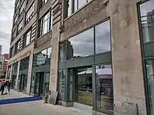 A greyish building with large glass doors.