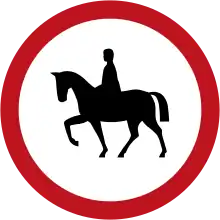 Round road sign circled in red with a rider in the middle