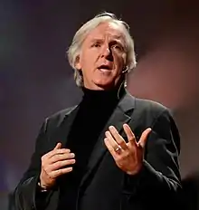 A photograph of Cameron speaking at the 2010 TED conference