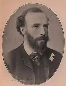 Black-and-white photographic portrait of a bearded gentleman in a suit