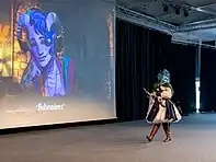 Jester Lavore cosplayer in front of an image of Molly