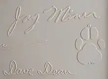 Jay Miner's signature from the top cover of a Commodore Amiga 1000 computer, along with his dog Mitchy's pawprint.