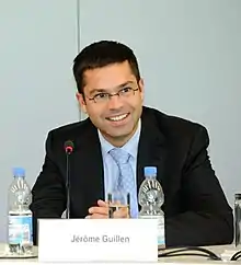 A sitting man facing the audience.