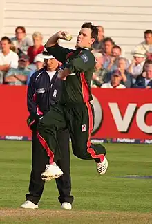 Jim Allenby bowling; he must ground some part of his foot behind his popping crease and within the return creases for the ball to be a legal delivery. As a member of the fielding side, he can also – after delivering the ball – attempt to run out a batsman by breaking the stumps with the ball before the batsman manages to return to the popping crease.