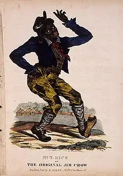 Man in blackface and ragged clothes with shoe worn through, dances with one hand on hip, fingers waving, white of eyes prominent as he looks upward.