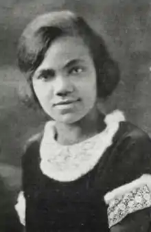 A young African-American woman wearing a dark dress with white lace collar and cuffs.