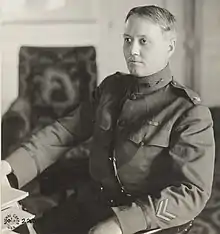 Black and white photo of John F. Madden seat at desk, left profile, looking right