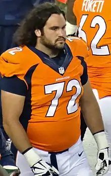 Candid photograph of Moffitt on a football sideline wearing a #72 Denver Broncos uniform