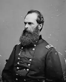 Black and white photo of a man with a thick beard and a receding hairline. He wears a dark military uniform with the two stars of a major general on the shoulder tabs.