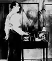 Dunninger with equipment used to duplicate the tricks of spiritualist mediums. A portable wireless set is strapped to his back