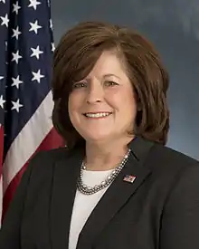 A portrait photo of Julia Pierson in front of a US flag