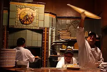 Traditional pizza dough being tossed