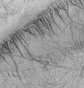 Gullies on one wall of Kaiser crater. Gullies usually are found in only one wall of a crater. Location is Noachis quadrangle.