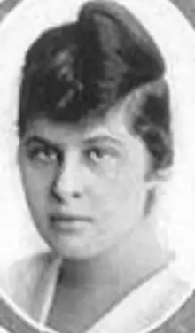 A young white woman with dark hair in an unusual asymmetrical updo, in an oval frame