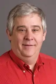 Middle-aged man with grey hair in a red polo shirt